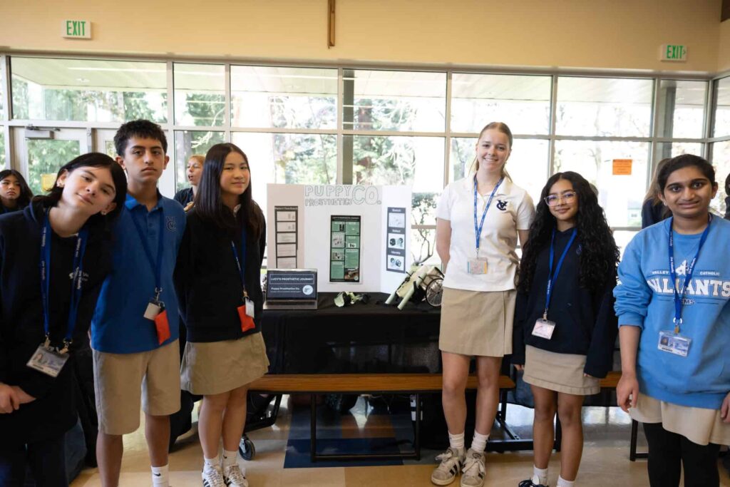 Dog mobility STEM students posing at table with their project